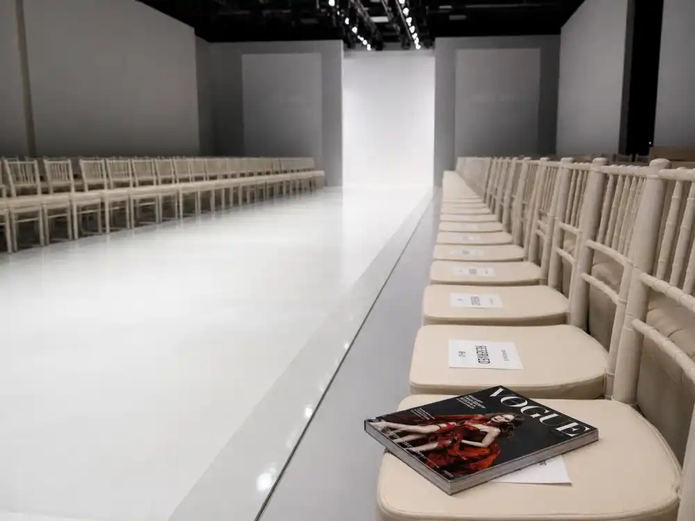 Empty fashion runway with Vogue magazine front row representing Apple Martin modeling career after Vanderbilt graduation