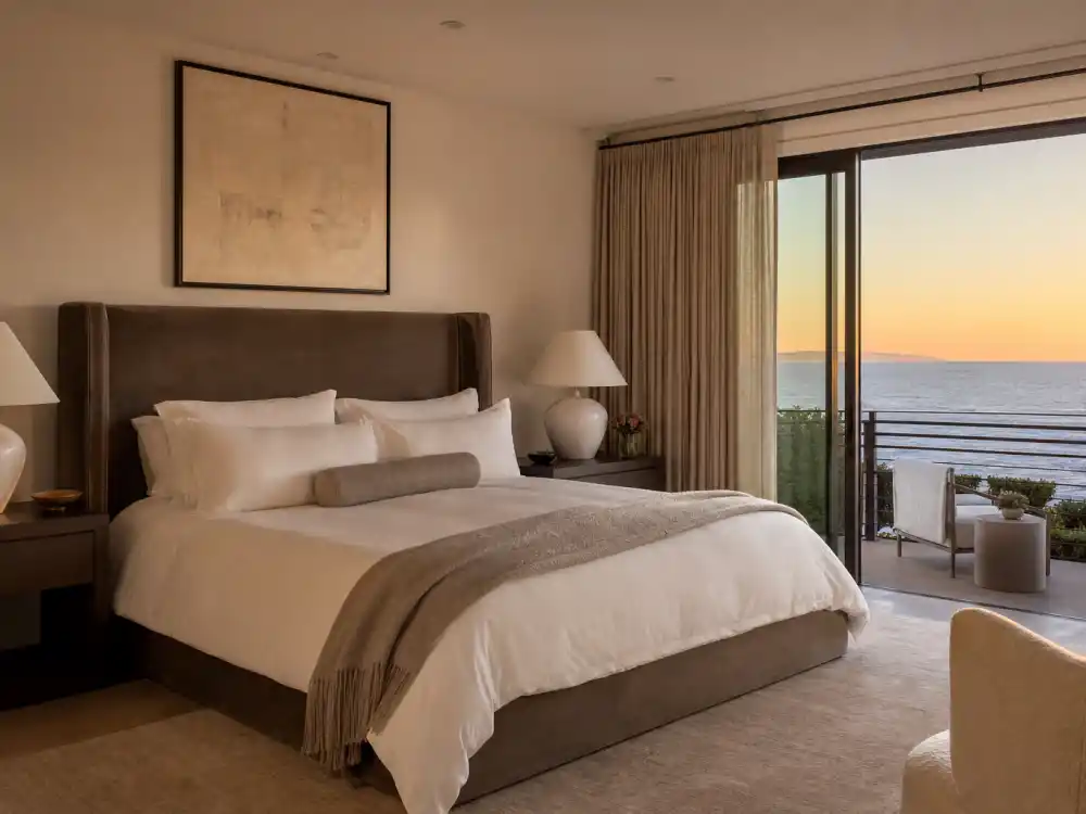 Velvet headboard primary bedroom with ocean view from Architectural Digest celebrity house tours