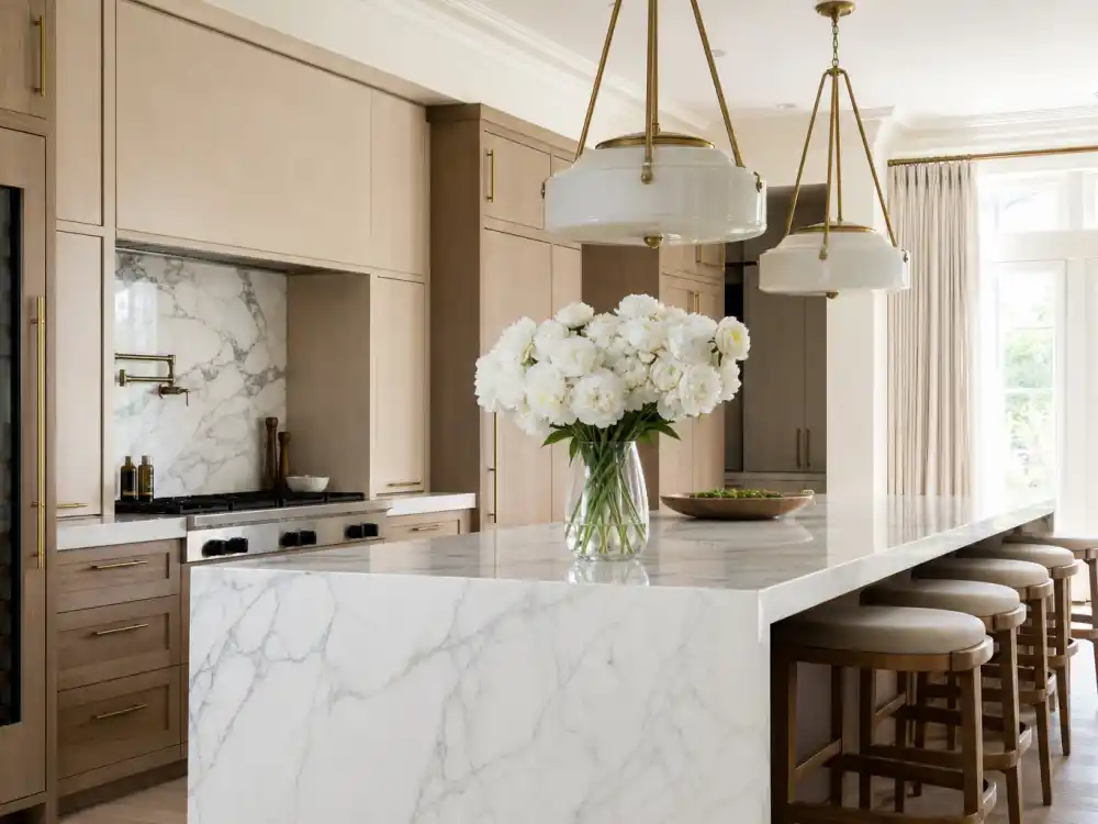 Calacatta marble kitchen island and brass pendants featured in Architectural Digest celebrity house tours