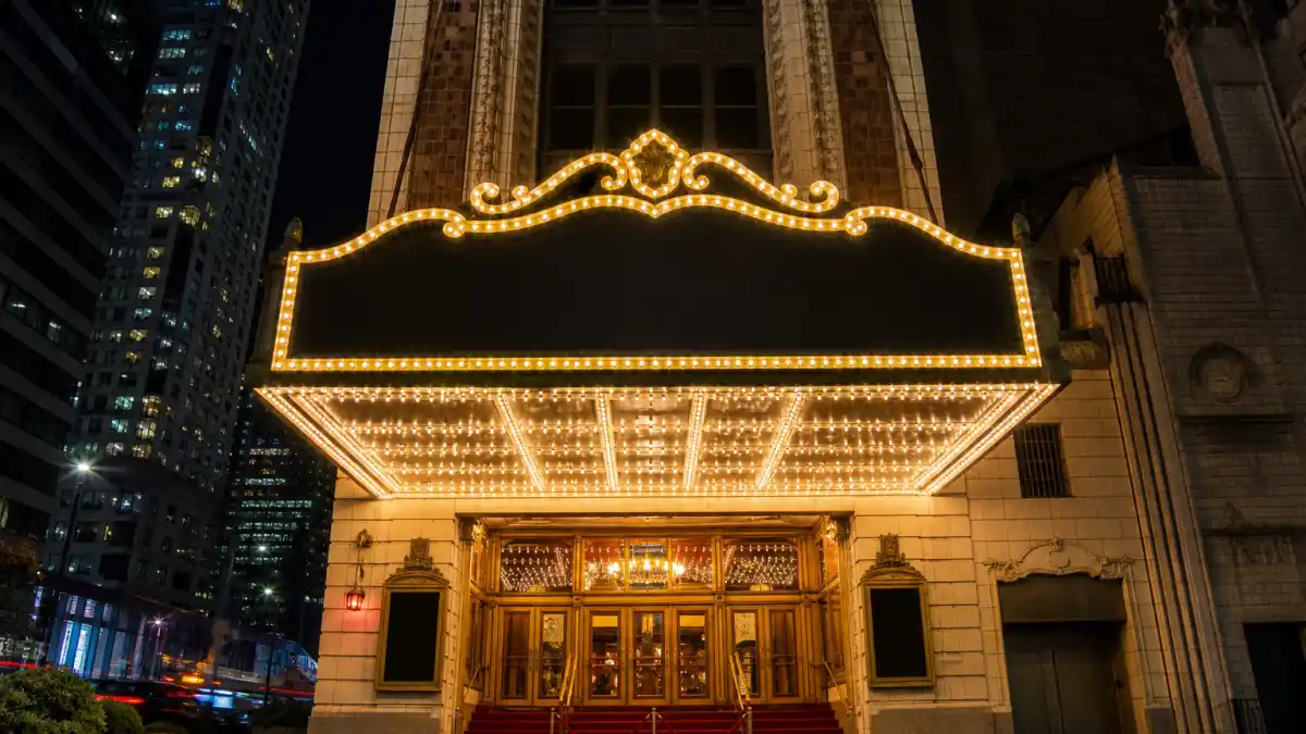 Broadway theater exterior with marquee lights representing where Ariana Grande Ethan Slater relationship began through Wicked