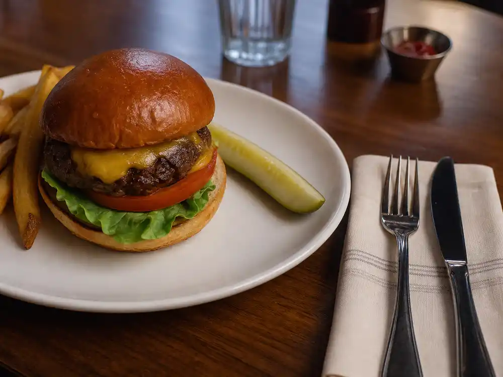 A restaurant burger plate and ordinary cutlery illustrate the Britney Spears restaurant report denial context.