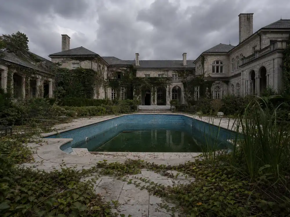 Overgrown swimming pool at a long-vacant luxury estate of celebrities who can't sell their mansion