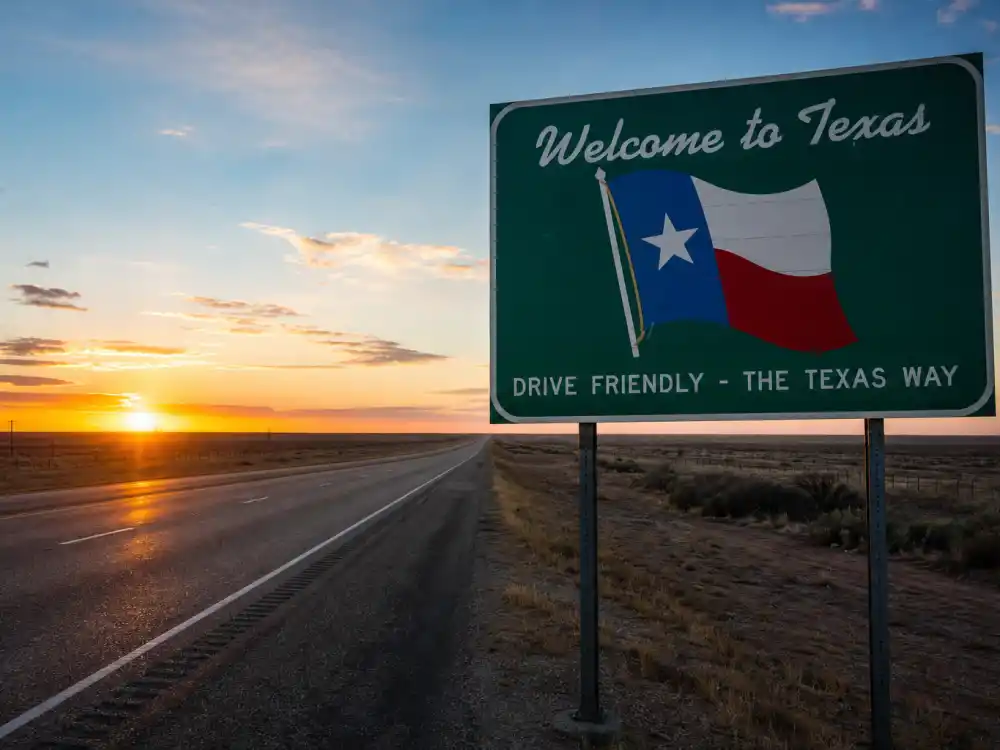 Welcome to Texas state highway sign at sunset symbolizing the migration of celebrities who moved to Texas
