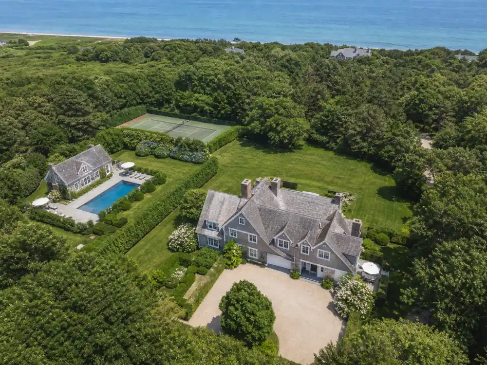 Aerial drone view of celebrity Hamptons houses compound with pool tennis court and ocean