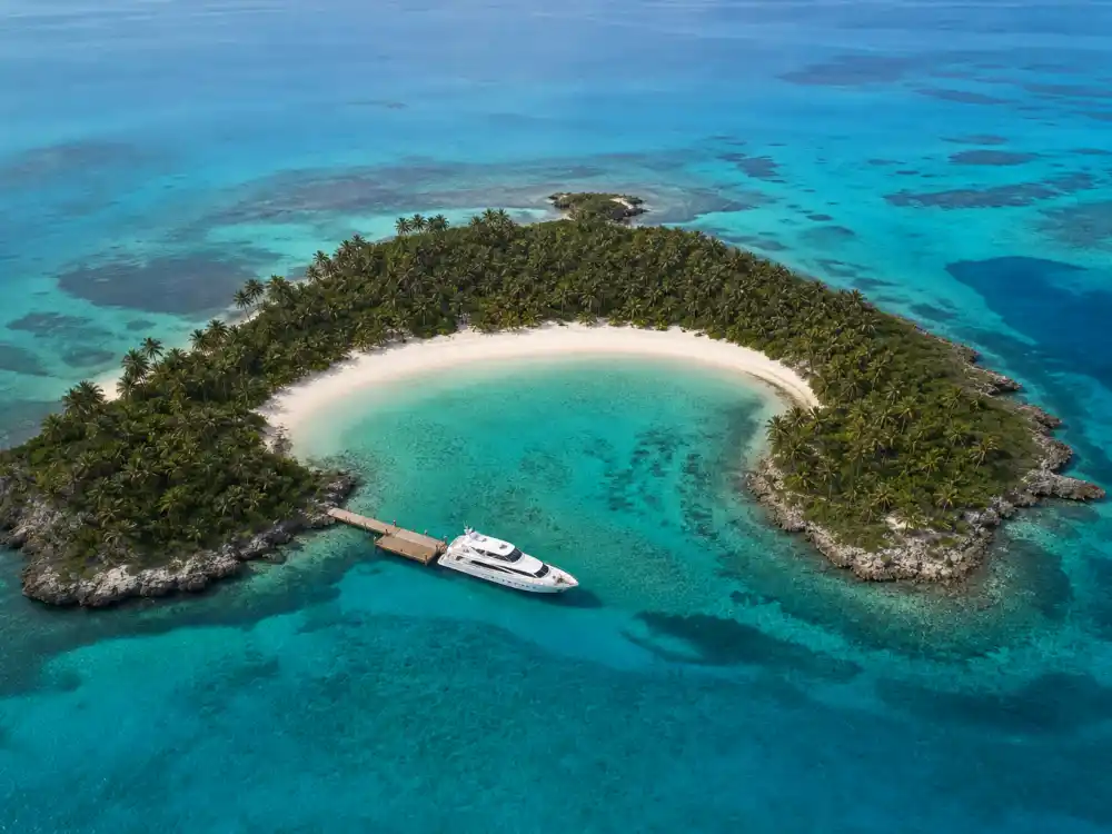 Aerial reef view of celebrity private islands with coral surrounding lagoon