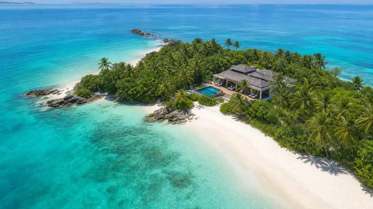 Aerial view of pristine tropical celebrity private islands with single luxury villa surrounded by turquoise water