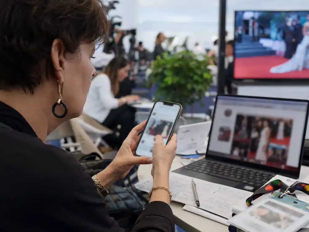 Fashion critic reviewing Cannes 2026 viral fashion reactions on a blurred phone screen.