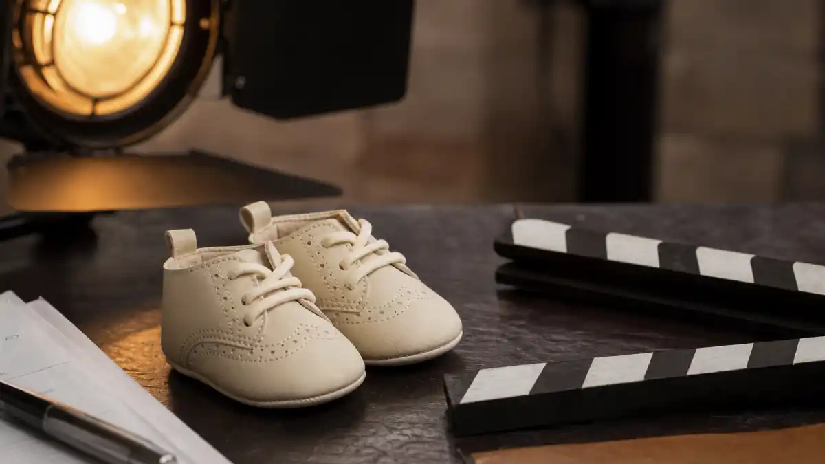 Jamie Foxx baby news is represented by baby booties beside Hollywood family photo frames.