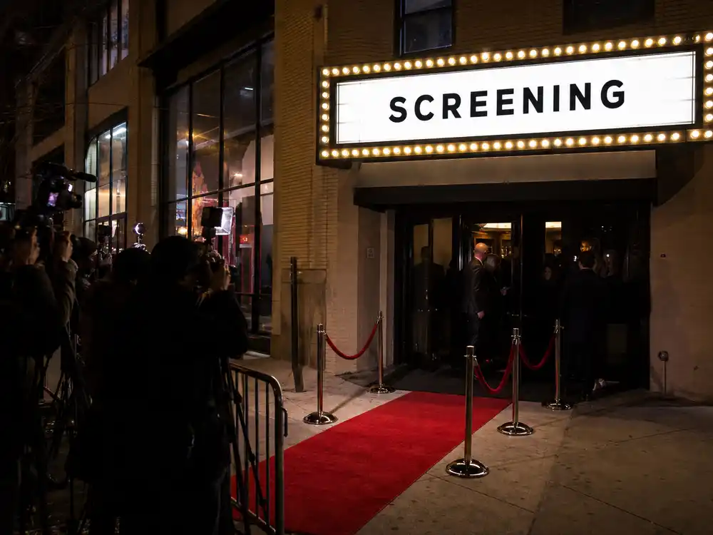 A private screening entrance evokes the Office Romance context around the Jennifer Lopez pap walk discussion.