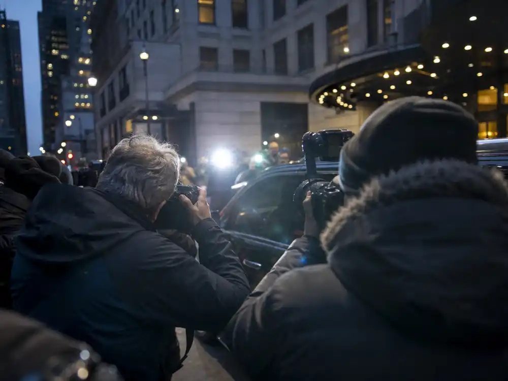 Paparazzi camera flashes outside a New York hotel illustrate the Jennifer Lopez pap walk backlash.