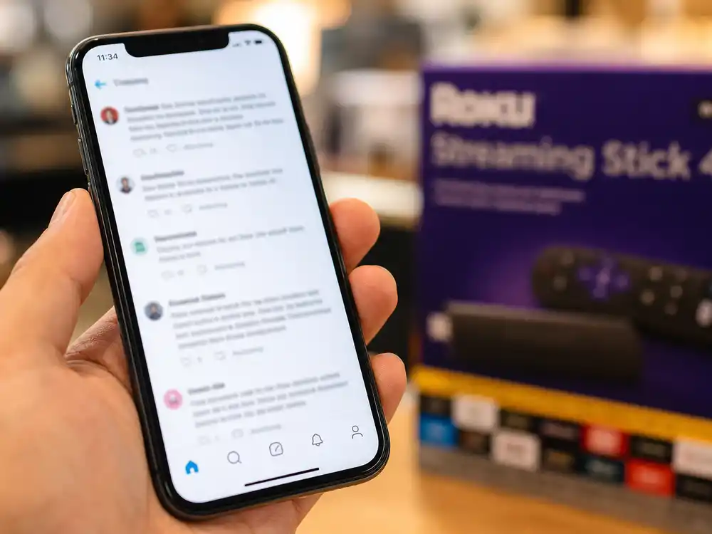 Social media posts on smartphone showing consumer reactions to Samsung TV packaging
