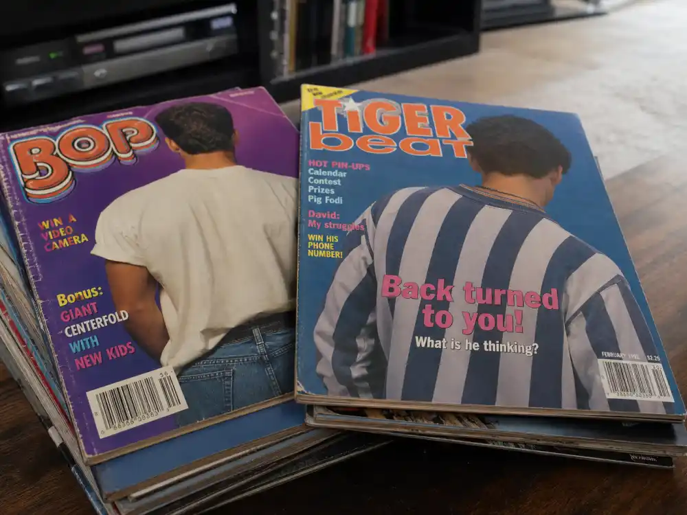 Stack of vintage 1990s teen magazines representing the Tiger Beat era behind 90s heartthrobs where are they now searches