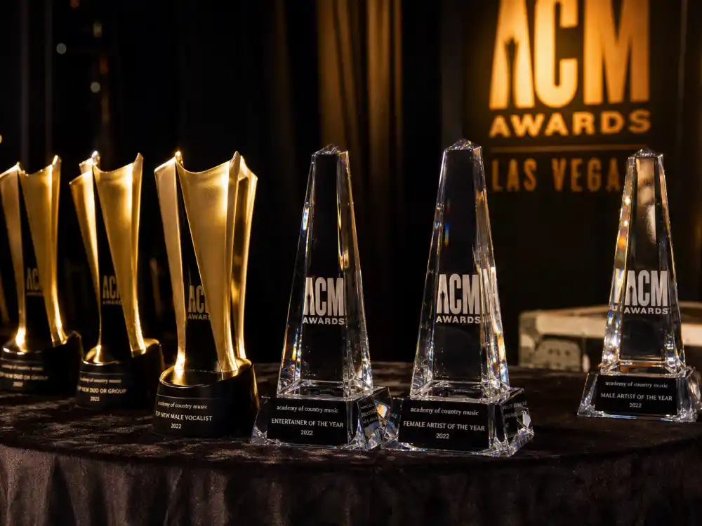 Golden ACM Award trophies on display backstage evoke every category on the ACM Awards 2026 winners list from Entertainer to New Artist honors