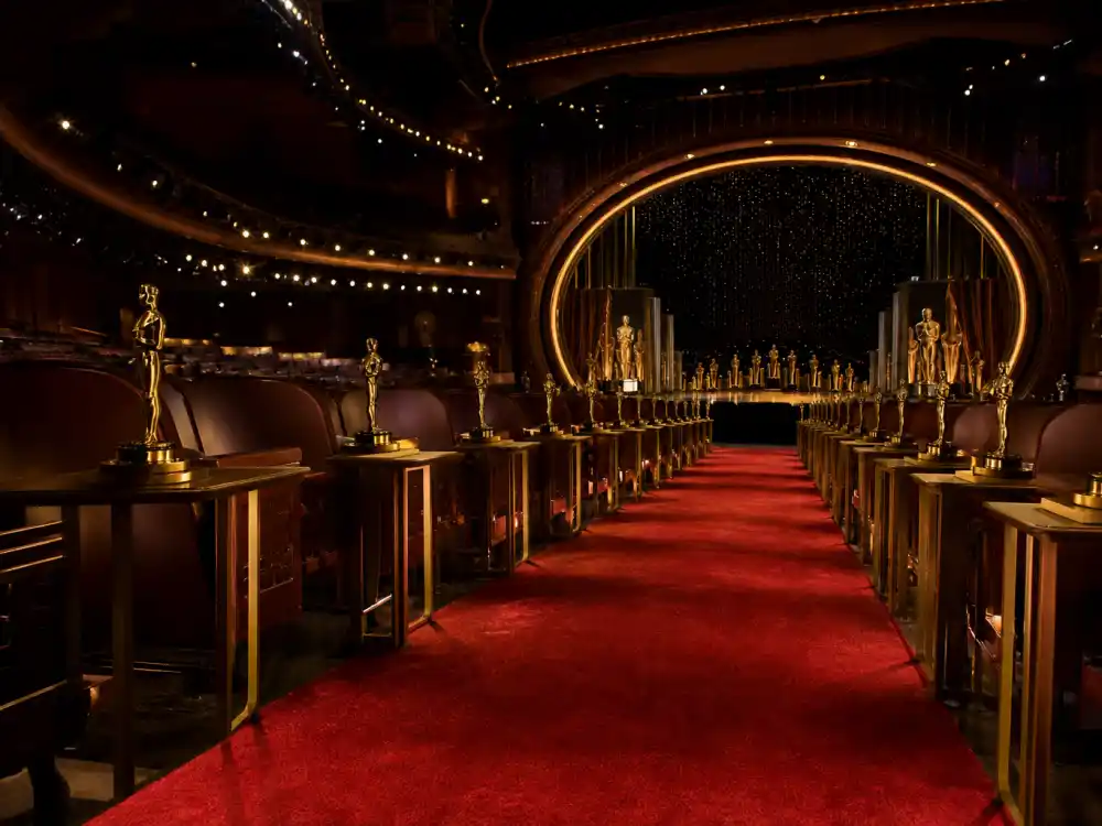 Hollywood awards theatre aisle with Oscar-style statuettes tied to the film half of actors who won both a Tony and an Oscar