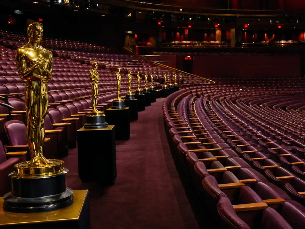 Hollywood awards theatre aisle with Oscar-style statuettes tied to the film half of actors who won the triple crown of acting