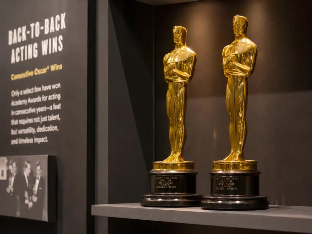 Paired golden statuette silhouettes on adjacent shelves symbolizing actors who won two Oscars in a row and back-to-back acting records
