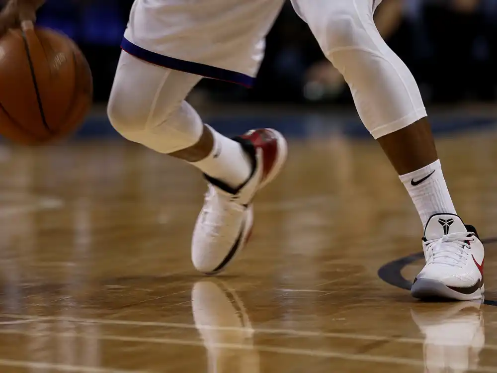 Basketball crossover dribble on hardwood for Allen Iverson signature move and NBA legend style