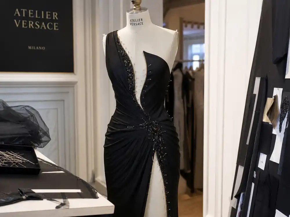 Atelier Versace couture atelier black evening gown with thigh slit on dress form defining Angelina Jolie leg slit dress Oscars construction