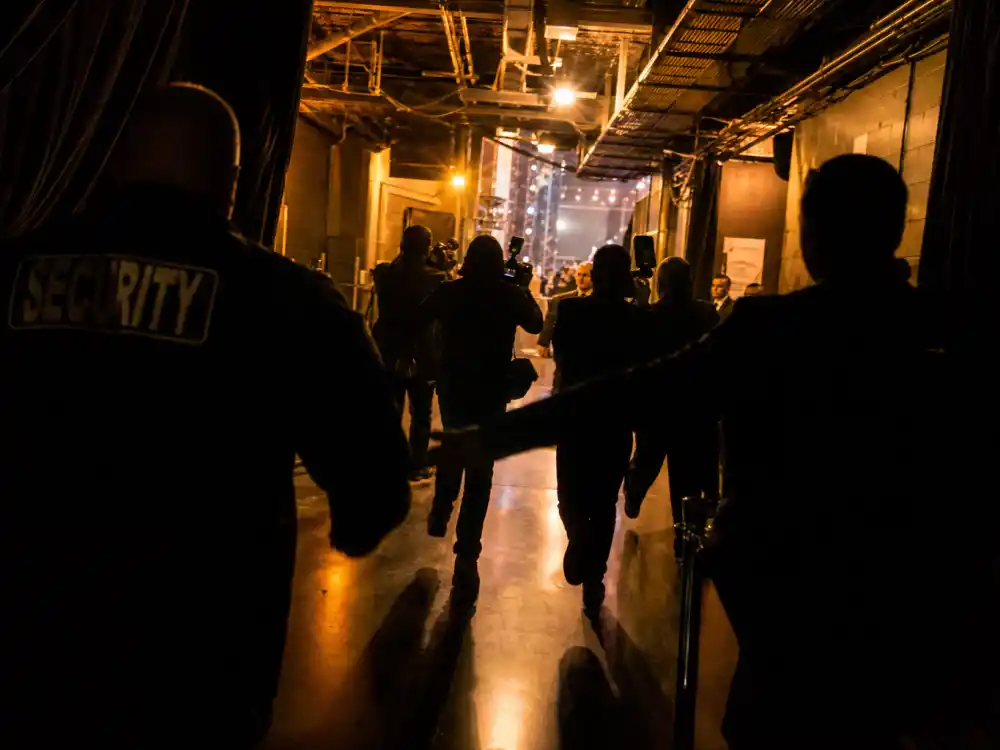Chaotic backstage awards corridor after onstage celebrity clash — security and press rush toward stage as award show feuds between celebrities spill beyond the podium