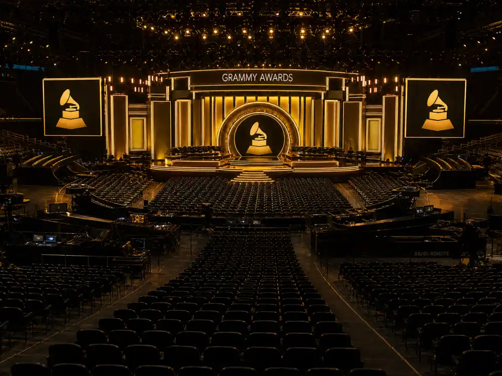 Grammy-style concert hall with empty rows facing a golden music awards stage — award show seat fillers explained at the Recording Academy telecast