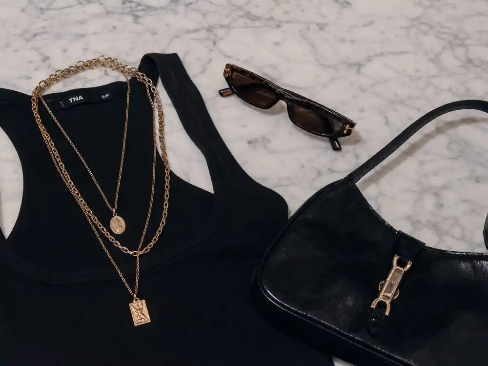 Layered gold chains and 90s retro sunglasses finishing Bella Hadid off duty street style accessory elevation