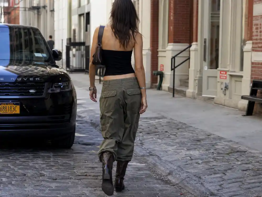 Olive cargo pants tube top and cowboy boots illustrating Bella Hadid off duty street style utility codes
