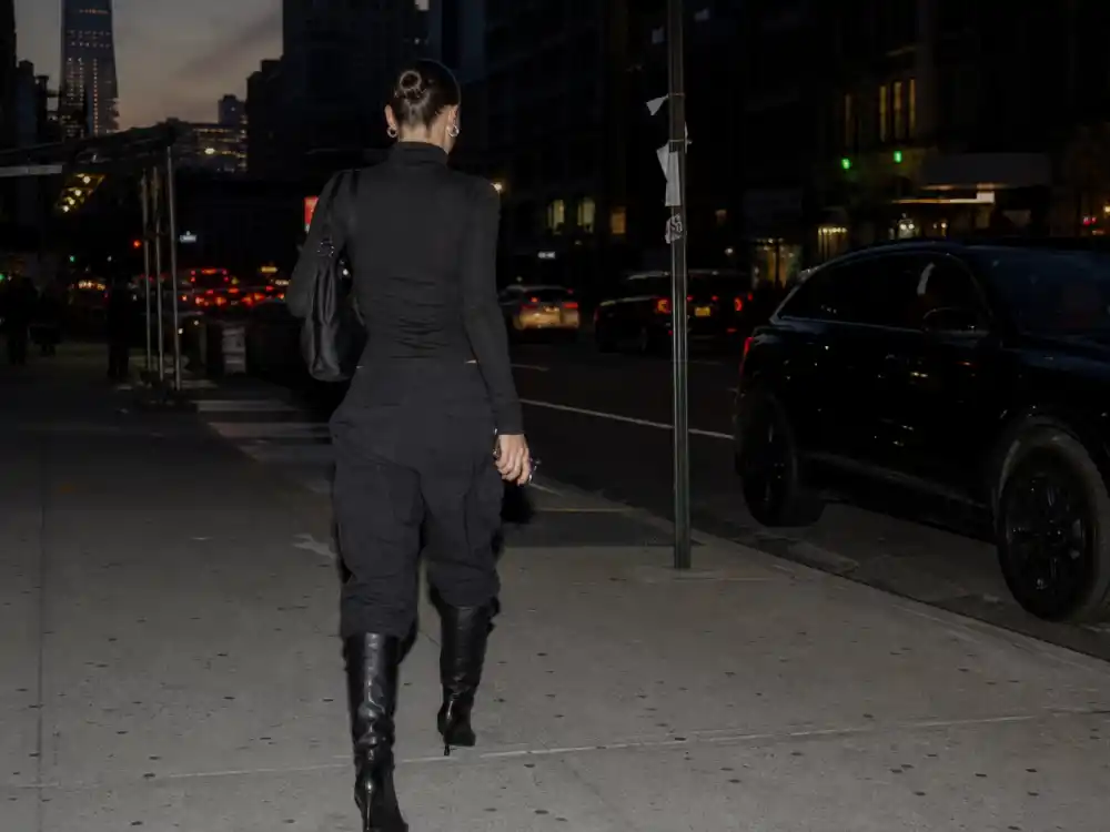 All-black cargo pants knee boots and slicked bun behind Bella Hadid off duty street style monochrome uniform
