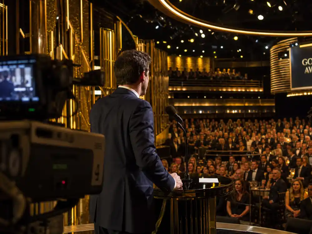 Vintage broadcast cameras capture the best award show hosts of all time delivering monologues on live television from a major ceremony stage