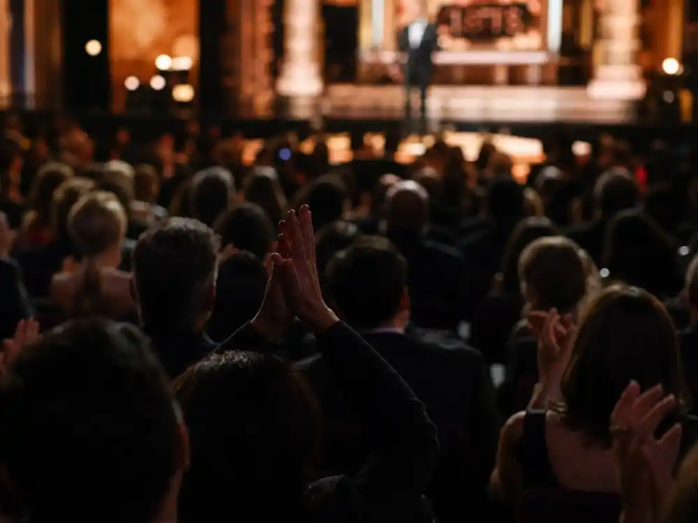 Laughing audience silhouettes react to jokes from contenders among the best Golden Globes host monologues ever during live ceremony broadcasts