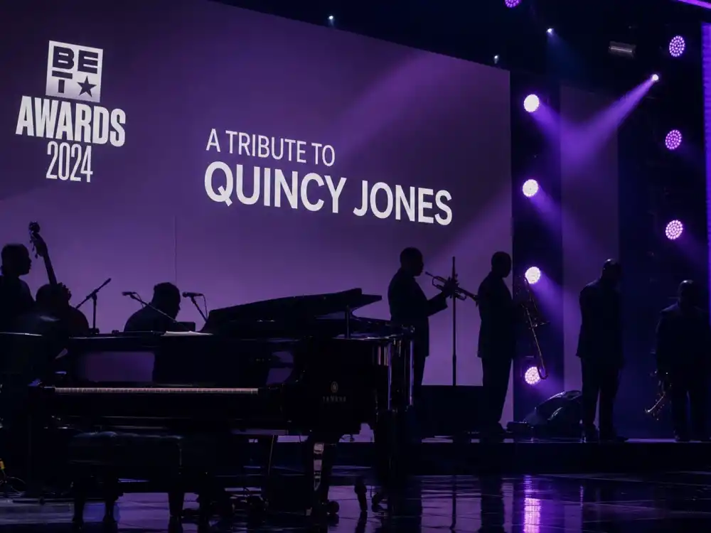 Tribute performance stage with brass silhouettes captures the medley format honoring BET Lifetime Achievement Award winners each June