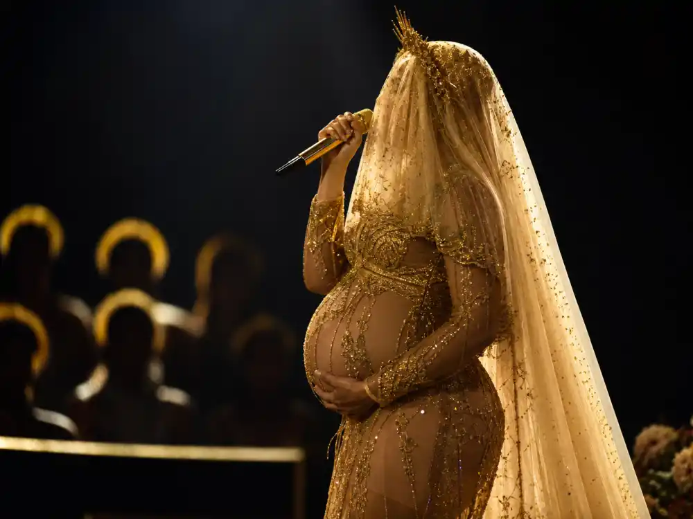 Anonymous performer in sheer gold Grammy maternity gown with floral veil on stage defining the Beyonce maternity fashion style 2017 twins reveal moment