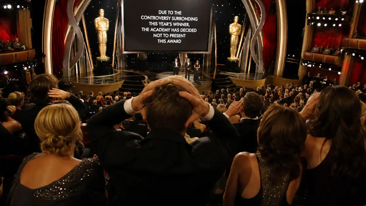 Biggest award show scandals ever — shocked awards theatre audience silhouettes react to controversial onstage announcement under golden Oscar-style spotlights
