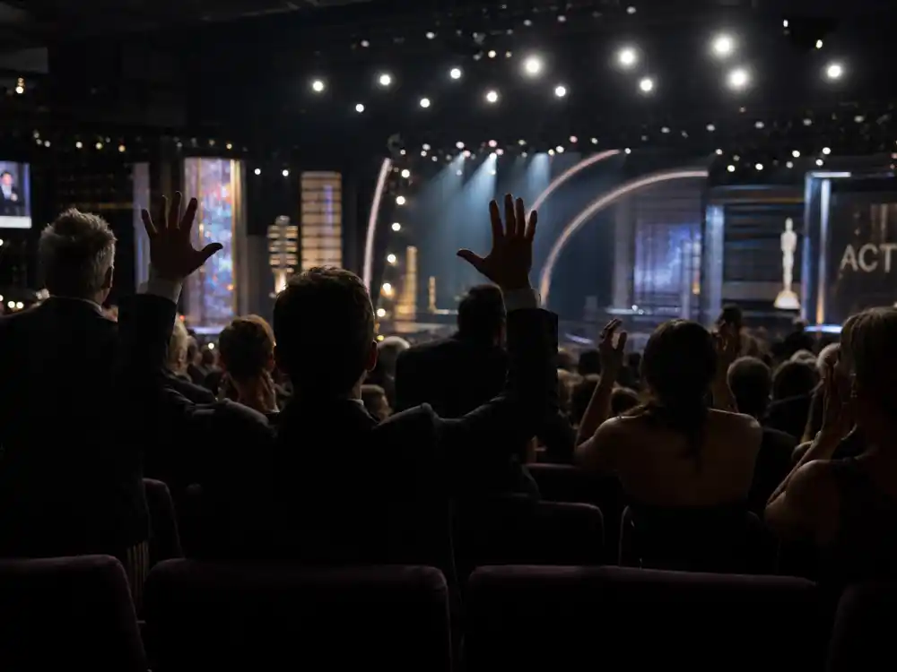 Shocked audience silhouettes reacting to one of the biggest Oscar upsets in history under theatre spotlights