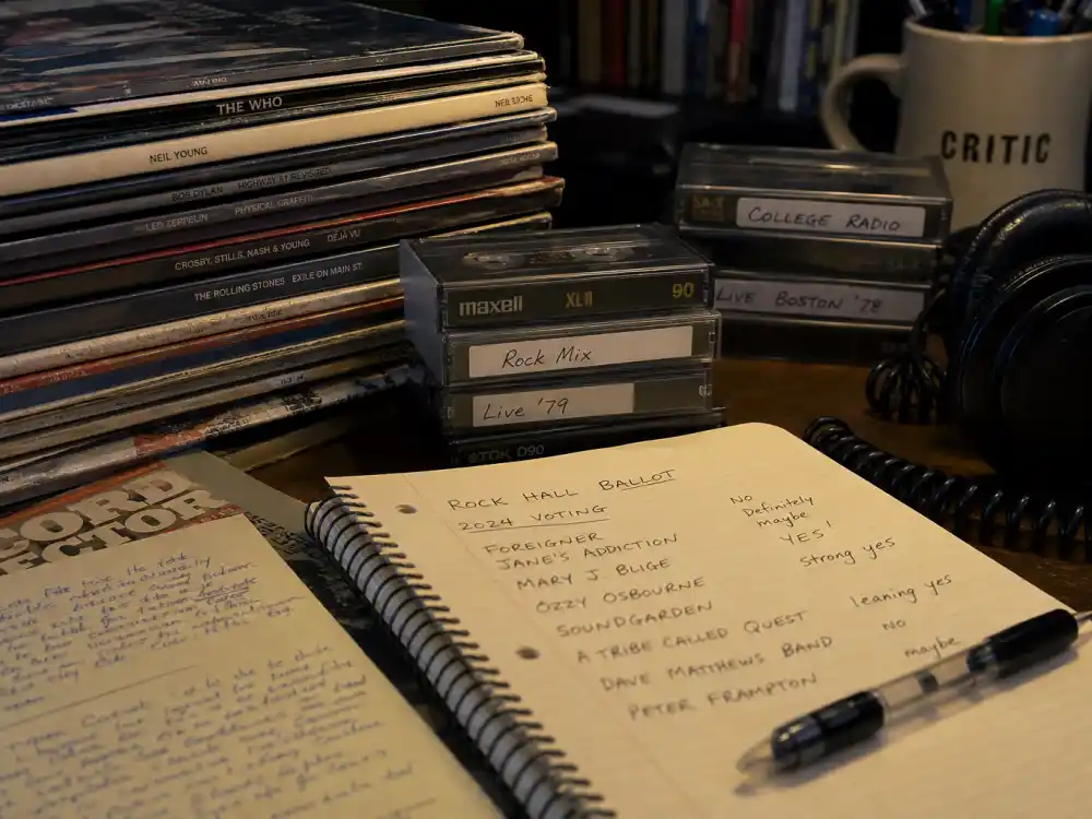 Vintage vinyl records on a critic desk tracking the biggest Rock and Roll Hall of Fame snubs across disco, electronic, and metal eras