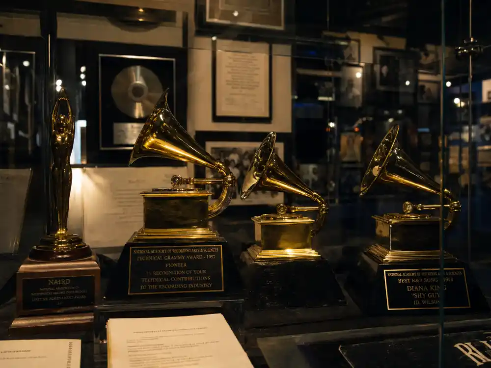 Vintage music award trophies in museum display for Billboard Music Awards vs Grammys — decades of ceremony history from 1990 BBMAs to NARAS Grammys