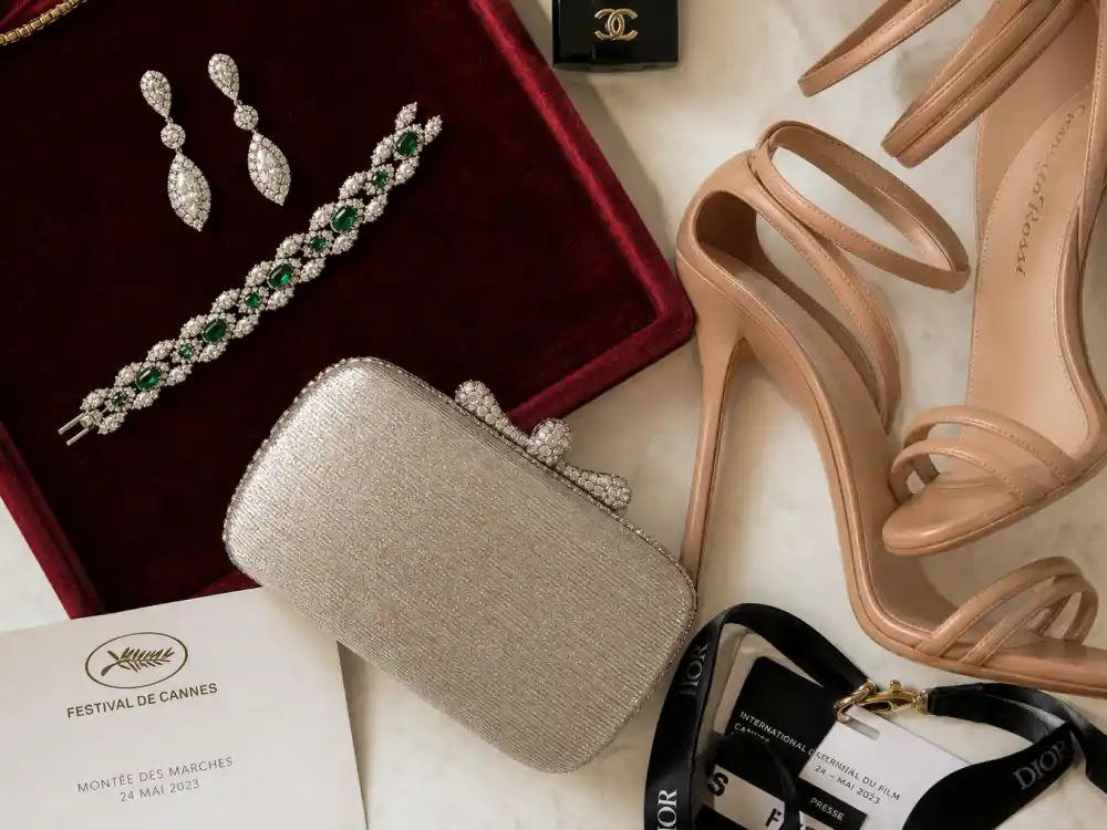 Diamond drop earrings emerald bracelet strappy heels and minaudière flat lay finishing cannes film festival celebrity style 2026 accessory stacking rules