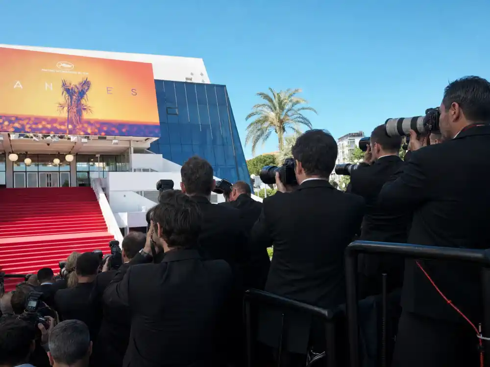 Press photographers on tiered risers beside Cannes red carpet rules and dress code steps during festival arrival windows