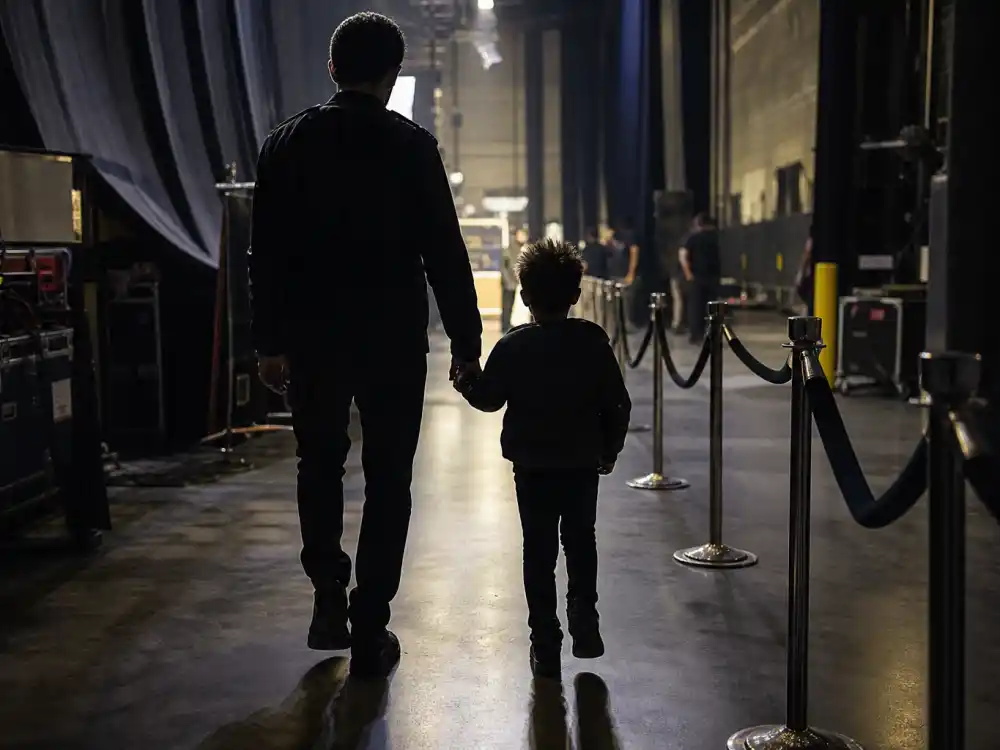 Parent child silhouette backstage at concert venue in Carter family privacy rules for kids — controlled tour appearances documented by People