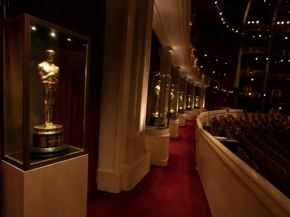 Hollywood awards theatre aisle with golden film statuettes for celebrities close to an EGOT hunting the Oscar leg