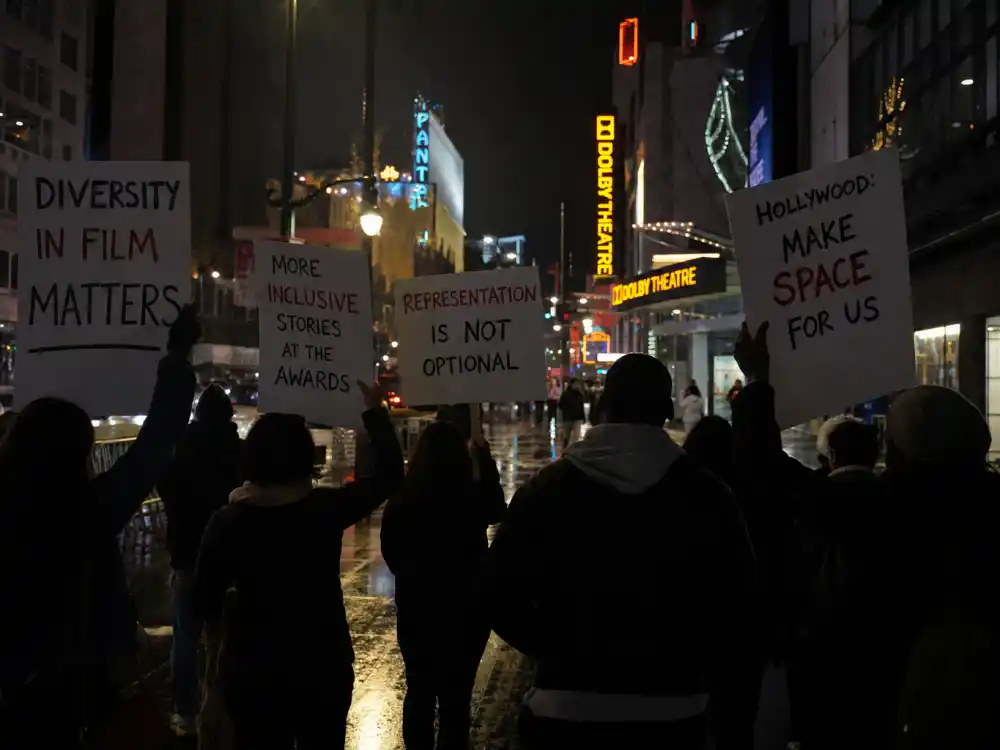 Hollywood Boulevard protest silhouettes outside a major film awards venue illustrate the public pressure behind celebrities who boycotted award shows for representation