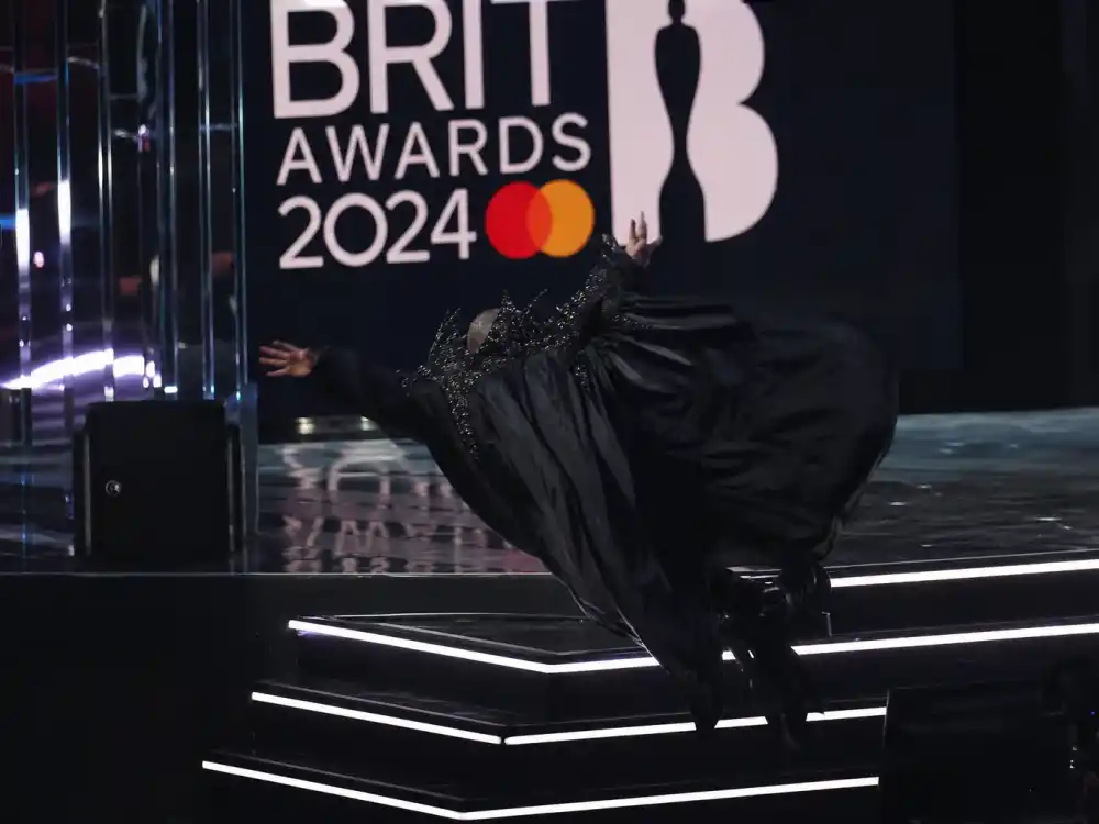 Cape-clad performer silhouette on Brit Awards stage illustrates Madonna 2015 backward fall in celebrities who fell on stage at award shows history