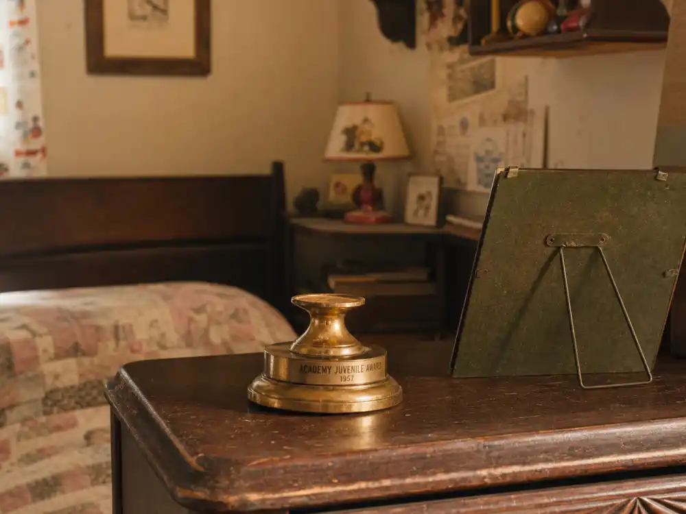 Empty juvenile Oscar-style pedestal on vintage dresser for celebrities who lost their award trophies Margaret O'Brien case study