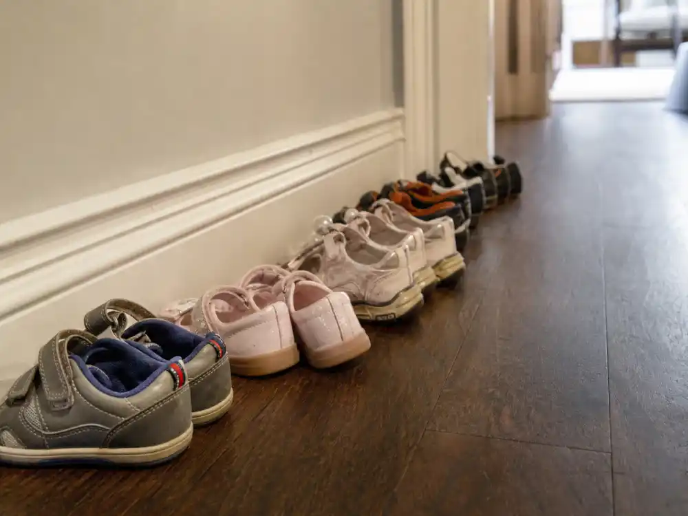 Multiple pairs of children shoes in hallway for celebrities who used surrogates list multi-child family editorial without identifiable faces