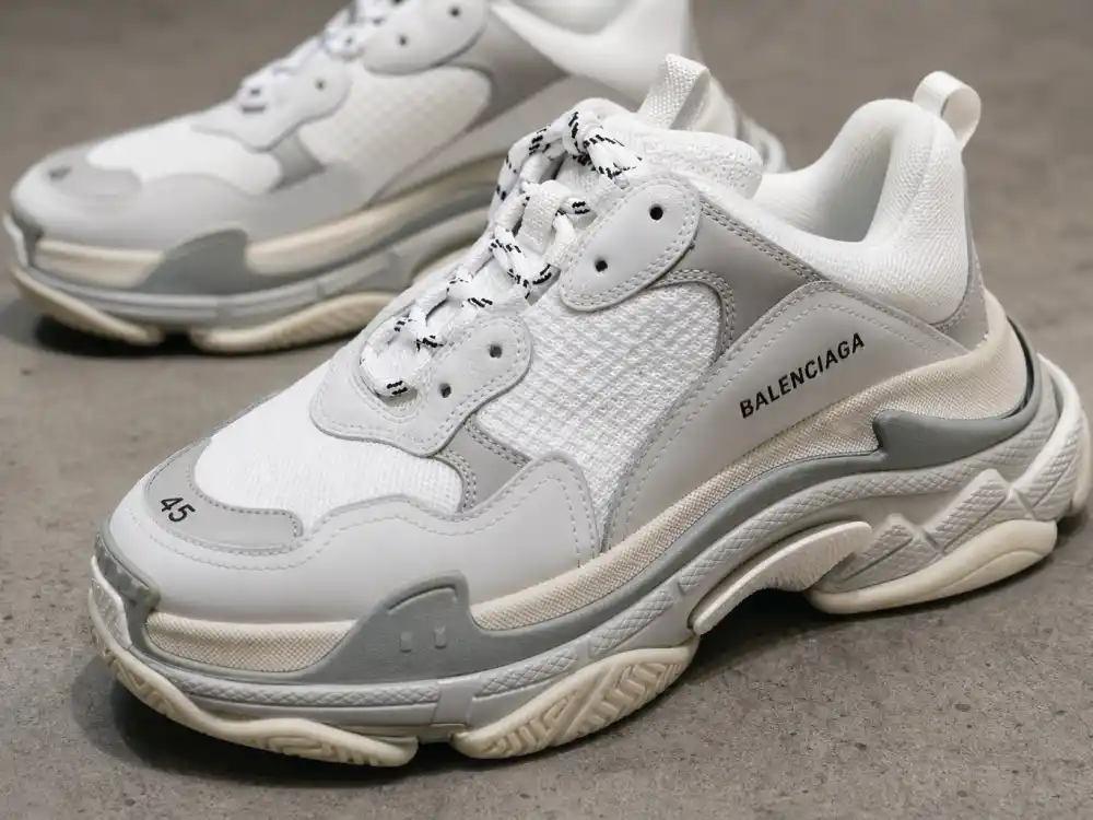 Balenciaga Triple S chunky sneakers on concrete display defining the footwear signature celebrities who wear Balenciaga pair with oversized tailoring and avant-garde streetwear