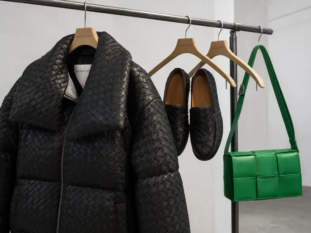 Bottega Veneta intrecciato puffer jacket woven loafers and green Cassette bag on hanger showing off-duty dressing codes celebrities who wear Bottega Veneta use between premieres and tour travel