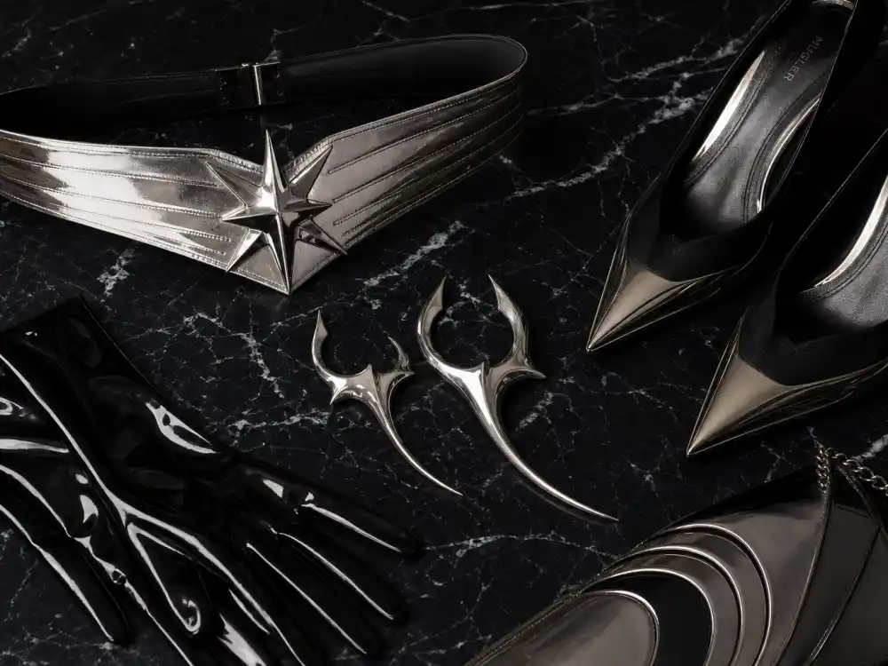 Mugler metallic belt sculptural earrings pointed pumps and latex gloves flat lay capturing accessory stacking rules celebrities who wear Mugler layer with corsetry and evening columns