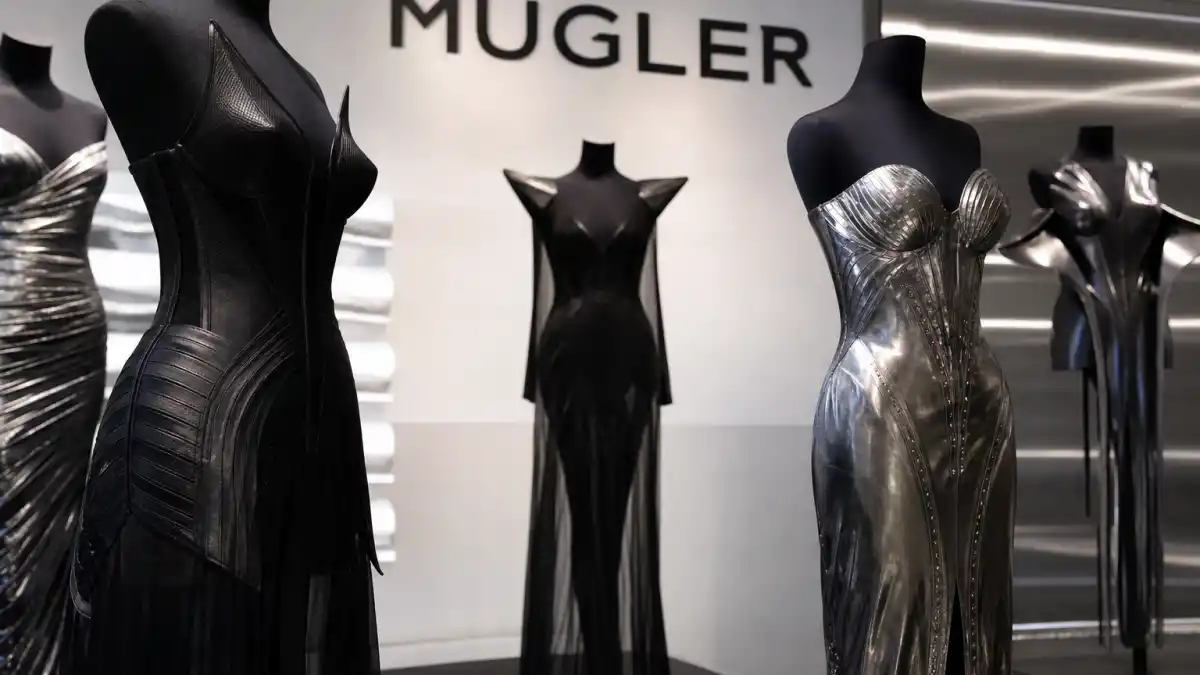 Mugler boutique interior with sculptural black corset dresses and metallic bodycon gowns on mannequins illustrating celebrities who wear Mugler avant-garde red carpet and couture culture
