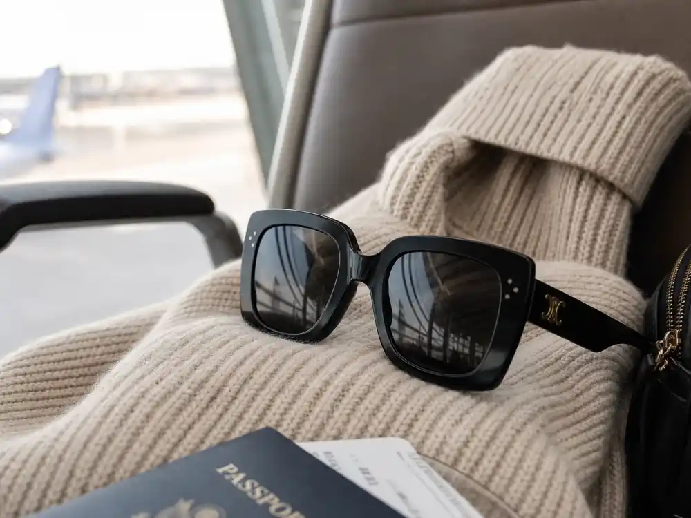 Oversized black sunglasses on cream knit finishing celebrity airport fashion street style face-framing accessory layer