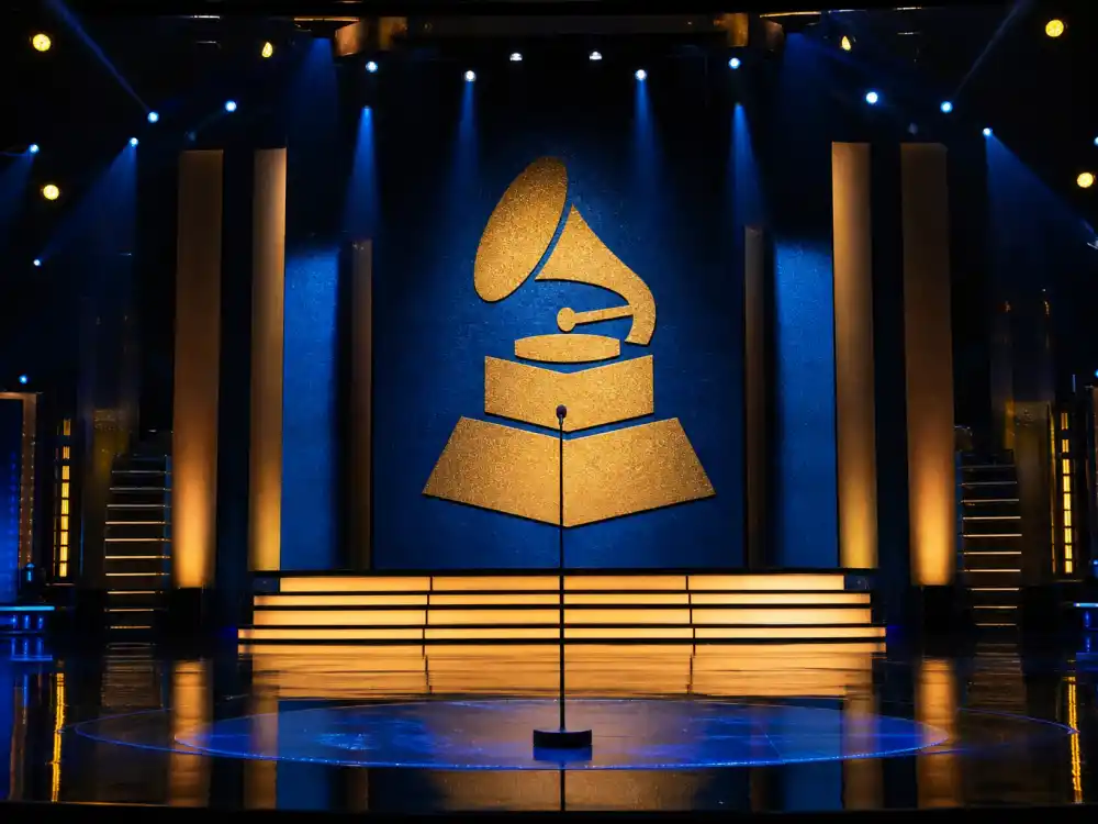 Music awards stage with golden gramophone trophy silhouette represents Grammy entries on lists of celebrity award show snubs controversial across every February telecast