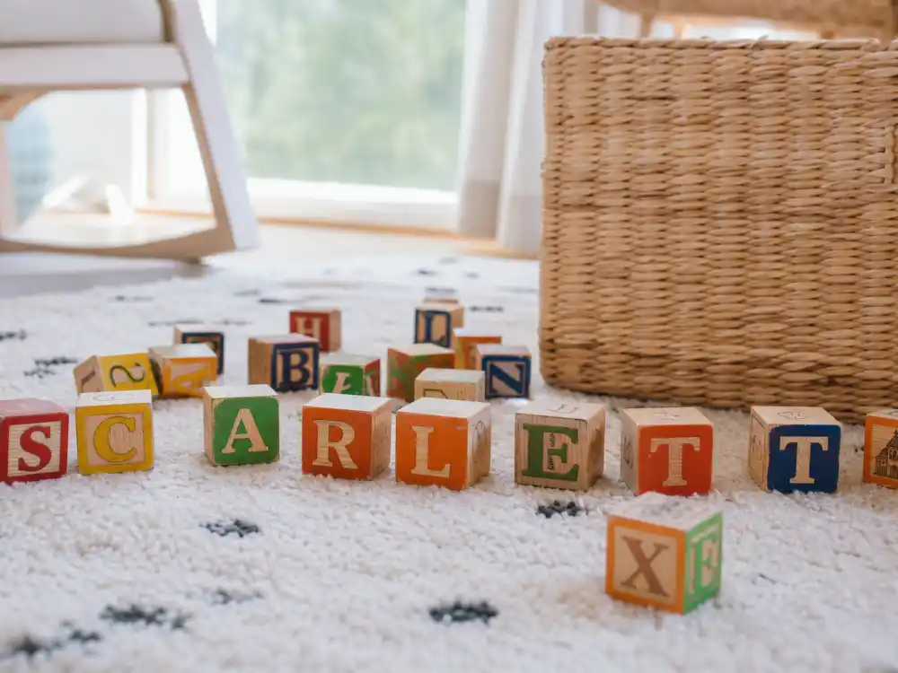 Colorful wooden alphabet letter blocks on nursery rug — celebrity baby names unique and trending decode culture starts with confirmed spellings from official posts